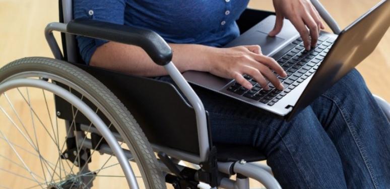 Person in wheelchair with laptop.