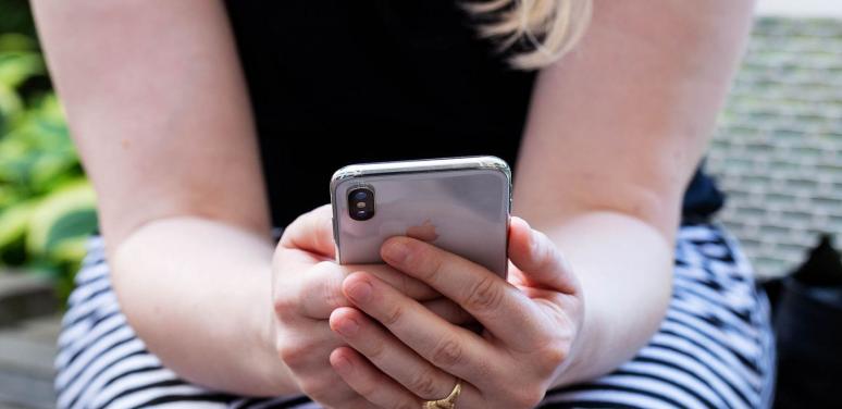 Woman sitting holding cell phone