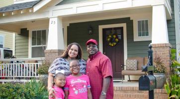 family standing in front of home